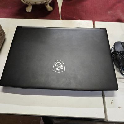 un ordinateur portable posé sur une table, avec une souris et un téléphone portable