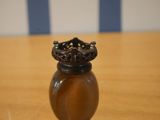 a small brown vase with a crown on top of it