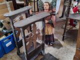 une statue représentant une femme debout dans une pièce remplie de meubles