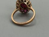 a close up of a gold ring with a pink stone