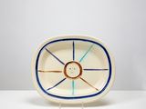 une image représentant une assiette blanche ornée d'un motif bleu et orange