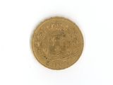 une vieille pièce de monnaie posée sur une surface blanche, sur fond blanc