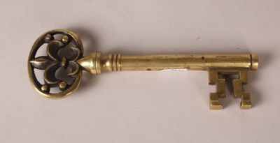 an old key is sitting on top of a white surface