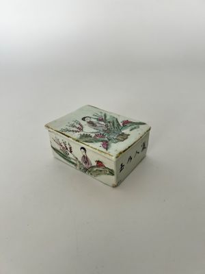 une petite boîte blanche décorée de fleurs, posée sur une table