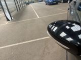 cars parked in a parking lot next to a fence and a building