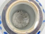 a blue and white vase sitting on a white surface