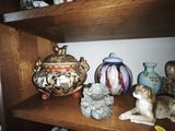 a shelf that has many different vases and figurines on it