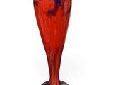 a red and blue vase sitting on a white surface