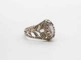 a close up of a silver ring with a purple stone