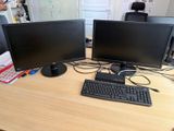 deux écrans d'ordinateur et un clavier sur un bureau