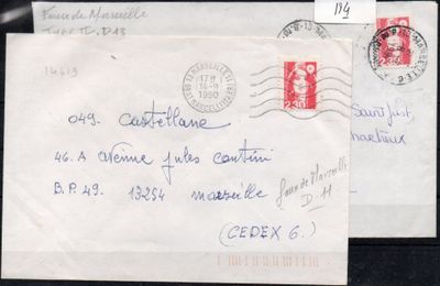 two envelopes with stamps on them sitting on a black surface