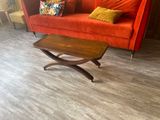 hardwood flooring in a living room with a red couch and a coffee table