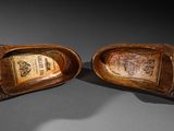 pair of brown shoes with a wooden heel on a gray surface