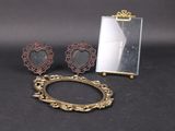 une photo représentant un miroir, un cadre et une paire de boucles d'oreilles posés sur une table
