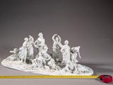 white statue of a group of people sitting on top of a white base