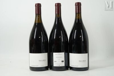 trois bouteilles de vin rouge sont alignées sur une surface blanche