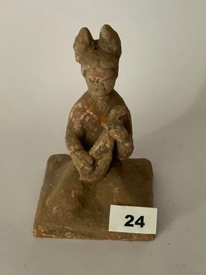 figurine représentant un homme assis sur un rocher sur lequel figure le chiffre 24