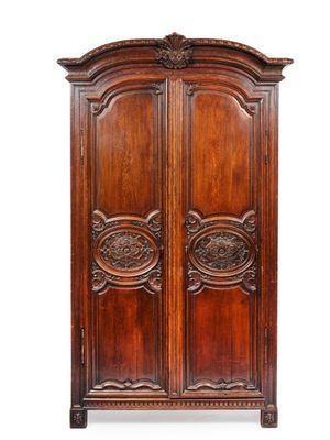 une vieille armoire en bois avec des gravures et des sculptures sur les portes