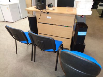 trois chaises devant un bureau sur lequel est posé un ordinateur