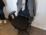 two people standing in a room with a chair and a desk