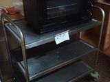a microwave sitting on top of a cart in a kitchen