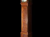 a tall wooden clock that is standing in the dark