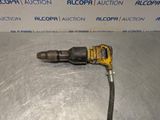 a close up of a drill on a metal surface with a sign in the background