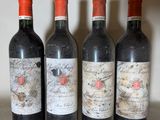 three bottles of red wine are lined up on a shelf