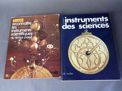 deux livres posés sur une table sur laquelle se trouve une horloge