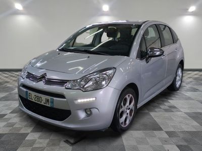 la petite voiture argentée est garée sur un carrelage à carreaux