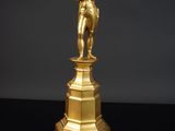 une image représentant une statue en or d'un homme sur un socle