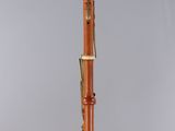 a wooden bassoon with a black top and gold trim