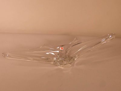 un objet en verre transparent posé sur une surface blanche