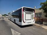 a white bus that is parked on the side of the road