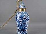 une image représentant un vase bleu et blanc muni d'une anse dorée
