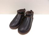 the children ' s black boots are lined up on a white surface