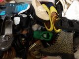 many pairs of shoes that are piled together on a bed