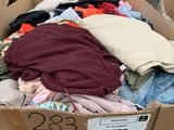 a cardboard box full of clothes on the street