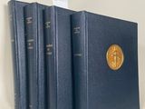 trois livres sont alignés sur une surface blanche