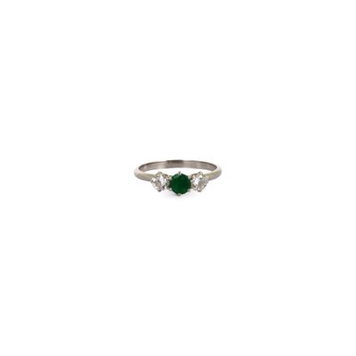 a close up of a ring with a green stone on it