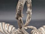 pair of silver plated spoons with decorative designs on them