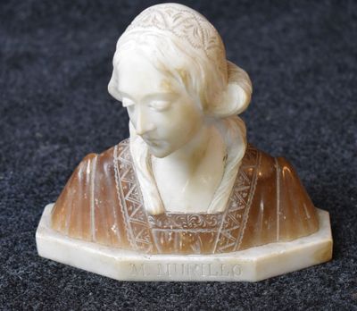 a small statue of a woman sitting on top of a table