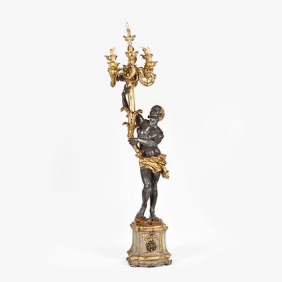 an image of a statue of a man holding a chandelier on a pedestal