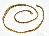 a close up of a gold chain on a white surface