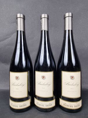 three bottles of wine are lined up on a table