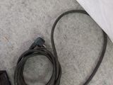 a black cord that is connected to a charger on the floor