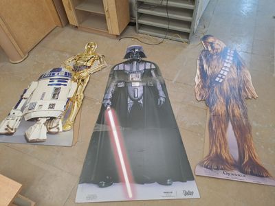 une affiche de Star Wars posée par terre à côté d'un Dark Vador et de Chew Chew Chew Chew Chew Chew Chew Chew Chew Chew Chew Chew Chew Chew Chew Chew Chew
