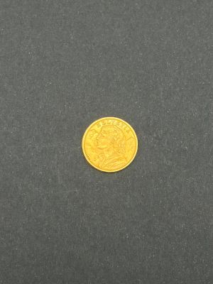 gros plan d'une pièce d'or sur une surface noire