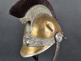 un vieux casque orné d'une plume, posé sur un socle