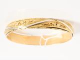 a close up of a gold ring on a white surface